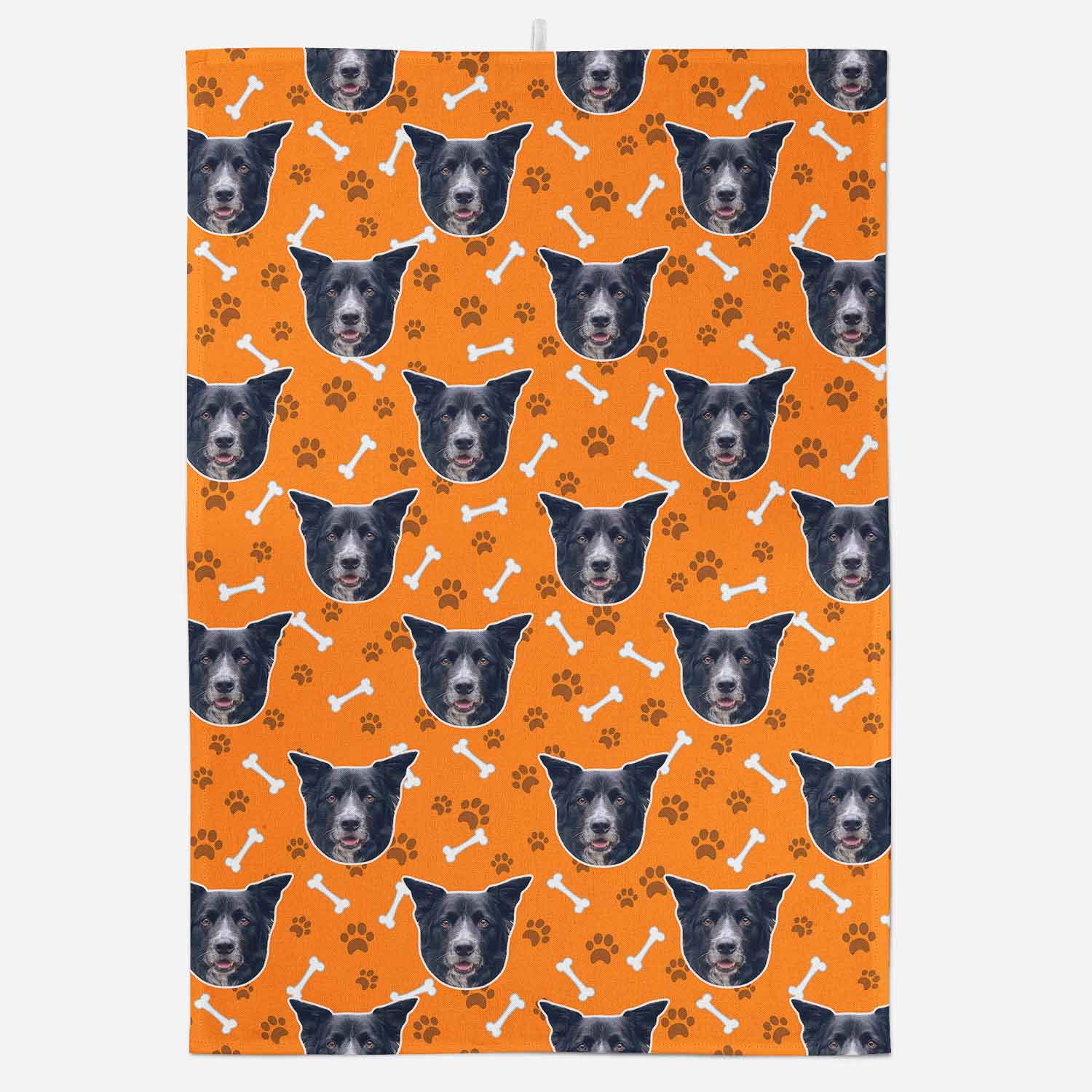 Patterned fabric with dog faces and paw prints on an orange background