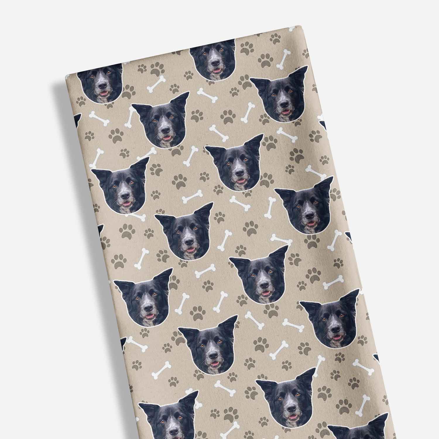 Fabric with dog faces and paw prints pattern on a beige background