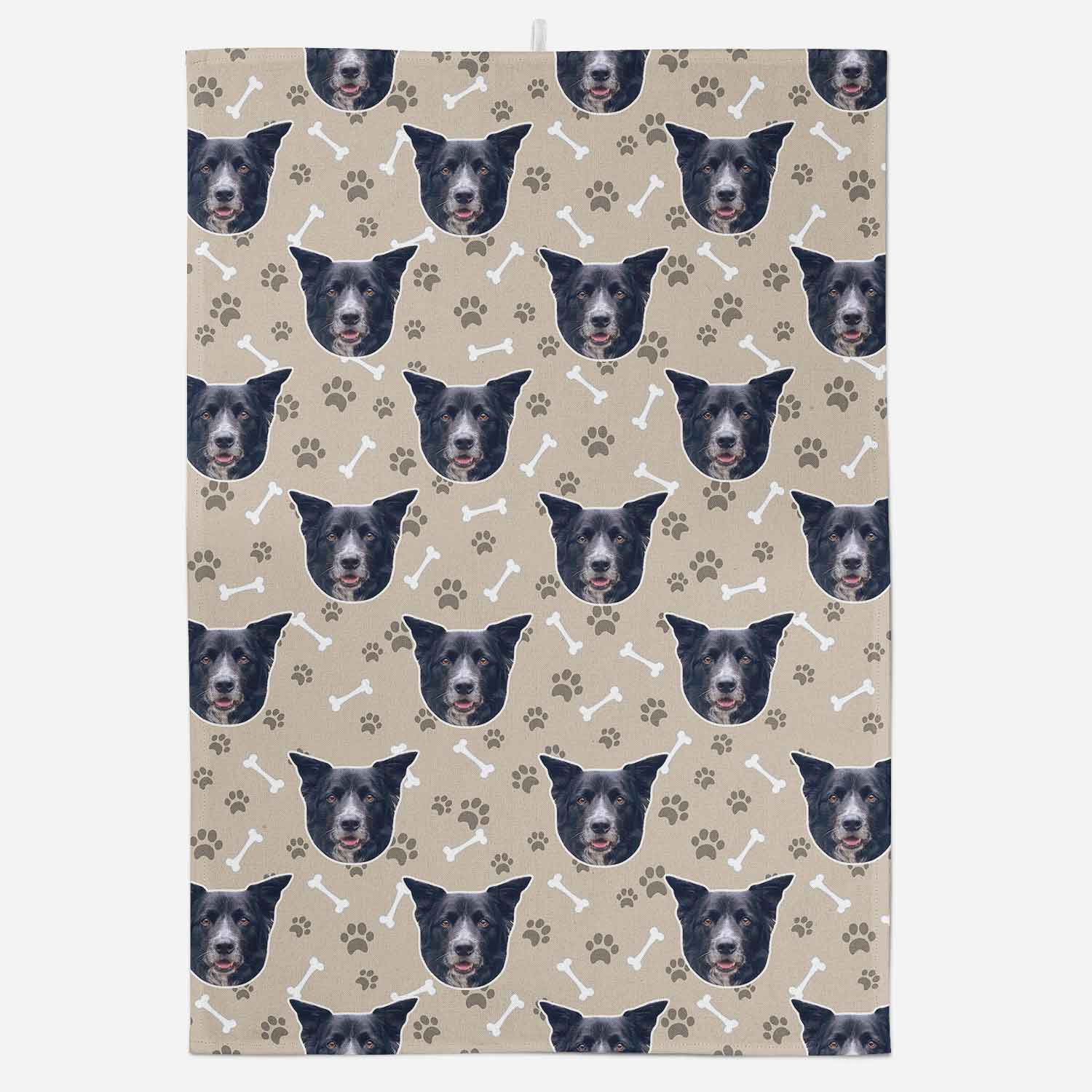 Patterned fabric with repeated images of a dog's face and paw prints on a beige background
