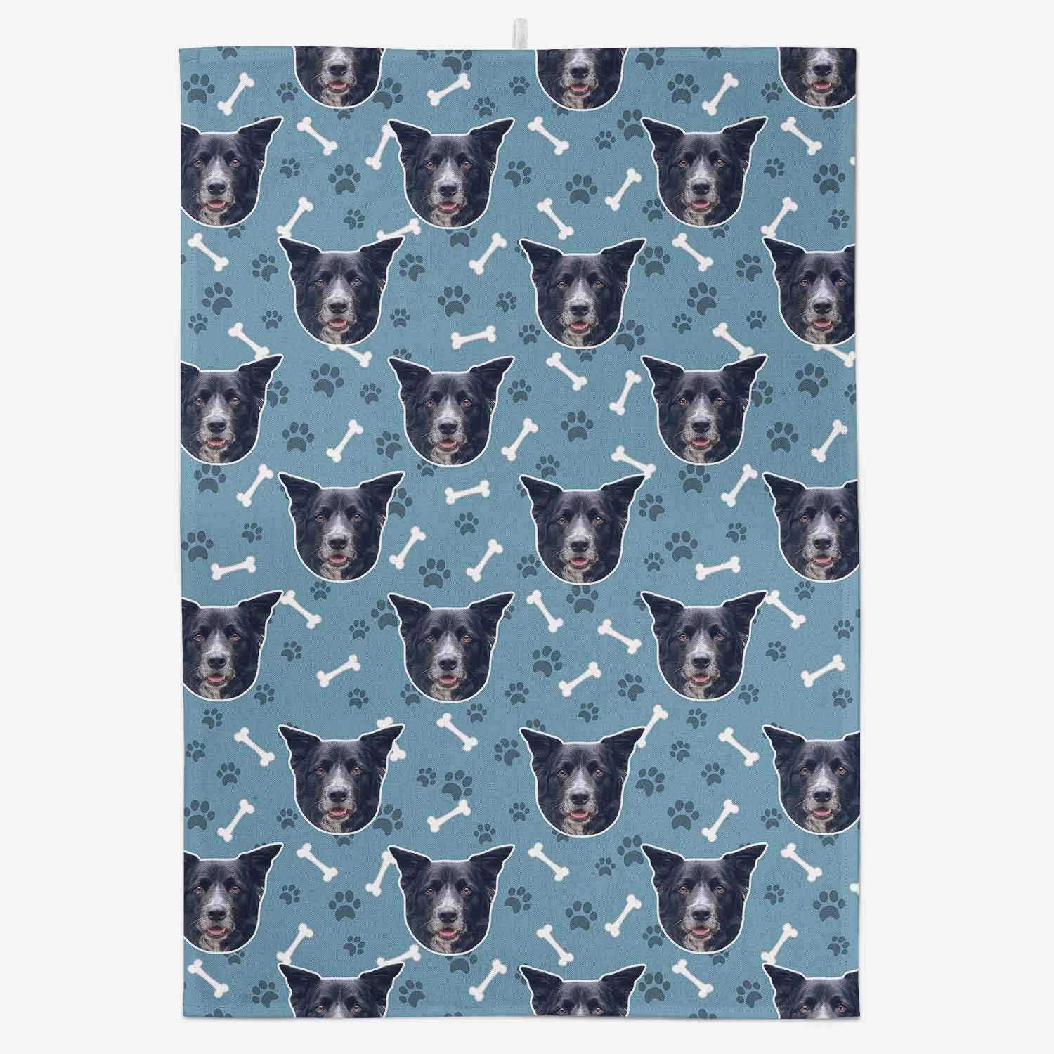 Patterned fabric with repeated images of a dog's face and bone, paw, and bone designs on a blue background.