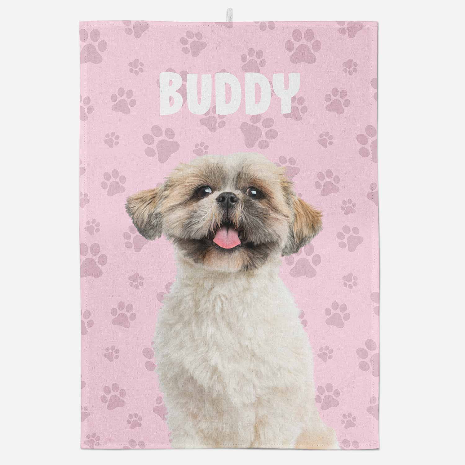 Dog with tongue out on a pink towel with paw prints and 'Buddy' text